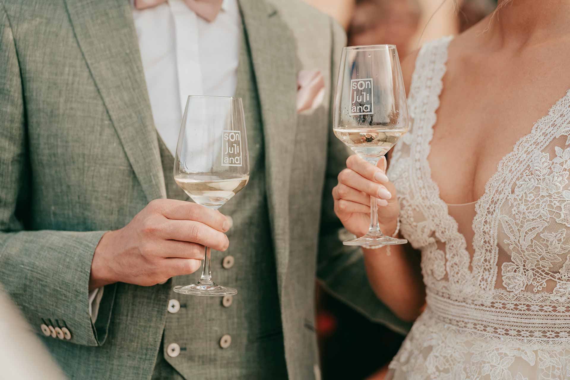 Anstoßen mit zwei Weingläsern beim Wein-Empfang der Bodega-Hochzeit auf Mallorca